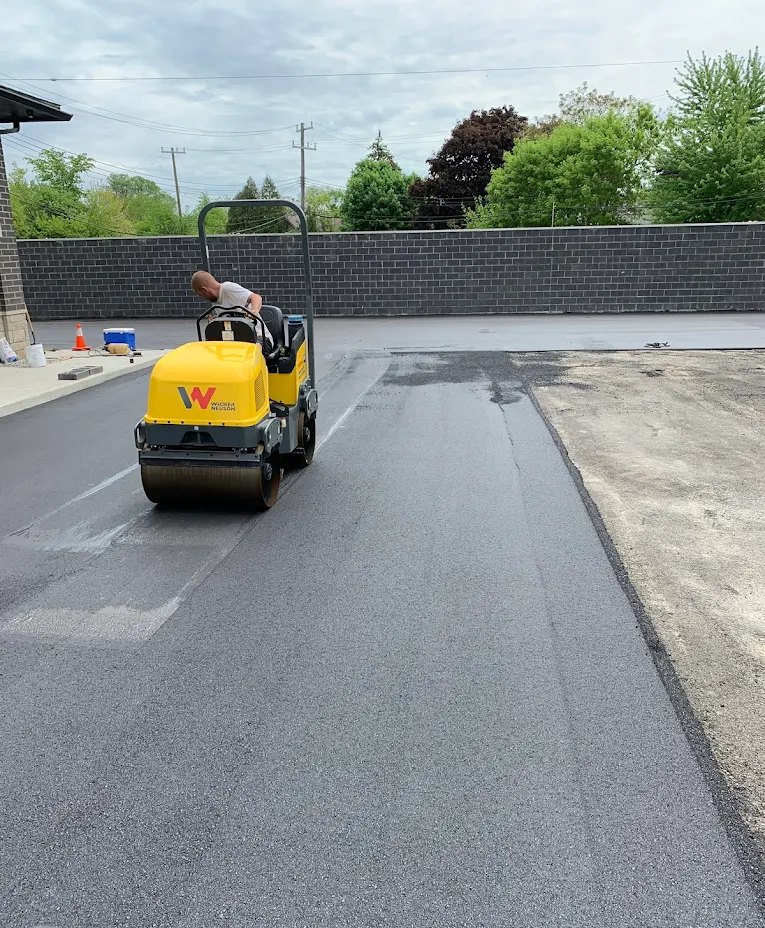 Roller compacting fresh asphalt on a paving job